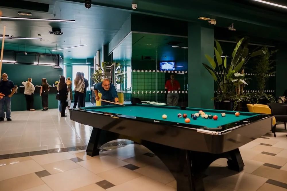 A player lining up a break on the table beside the seating area