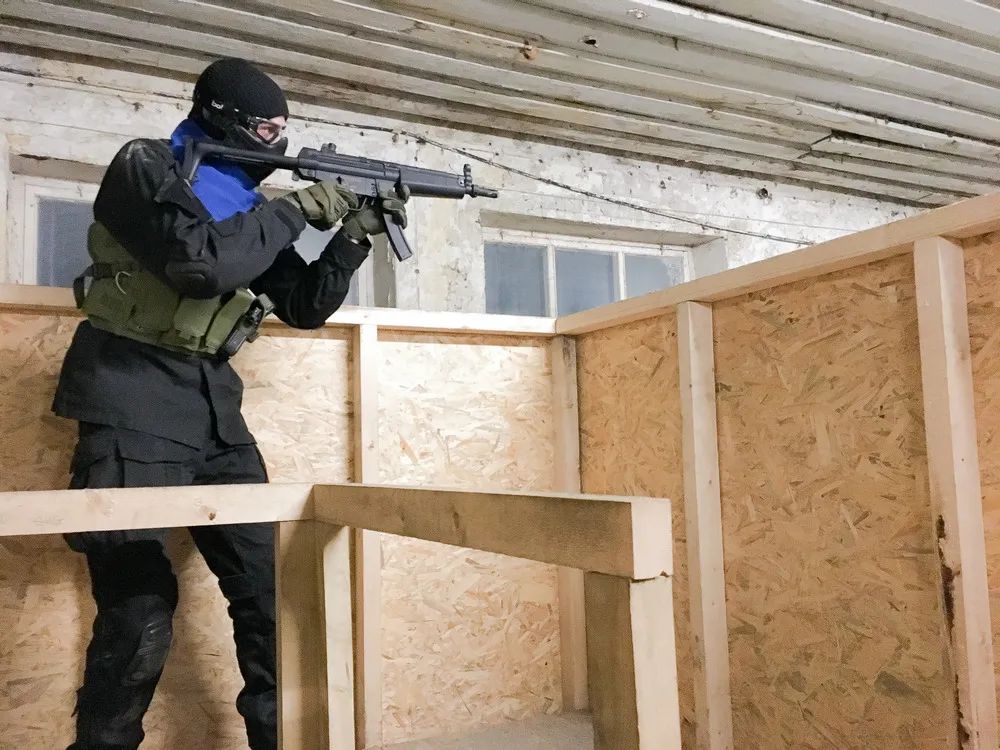 Viens airsoft spēlētājs tēmē skatoties uz priekšu. Airsoft iekštelpu laukums.