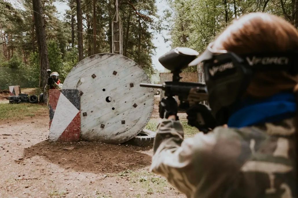 MEITENE MASKĀ TĒMĒ AR EKIPĒJUMU UZ SPOLES PUSI, KUR STĀV CITS SPĒLĒTĀJS