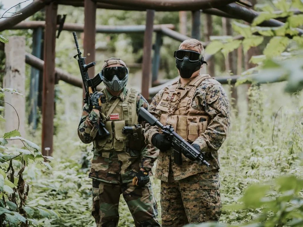 Kamuflāžā cilvēki ar airsoft ieročiem GUNSnLASERS Mežaparka izklaides parkā!