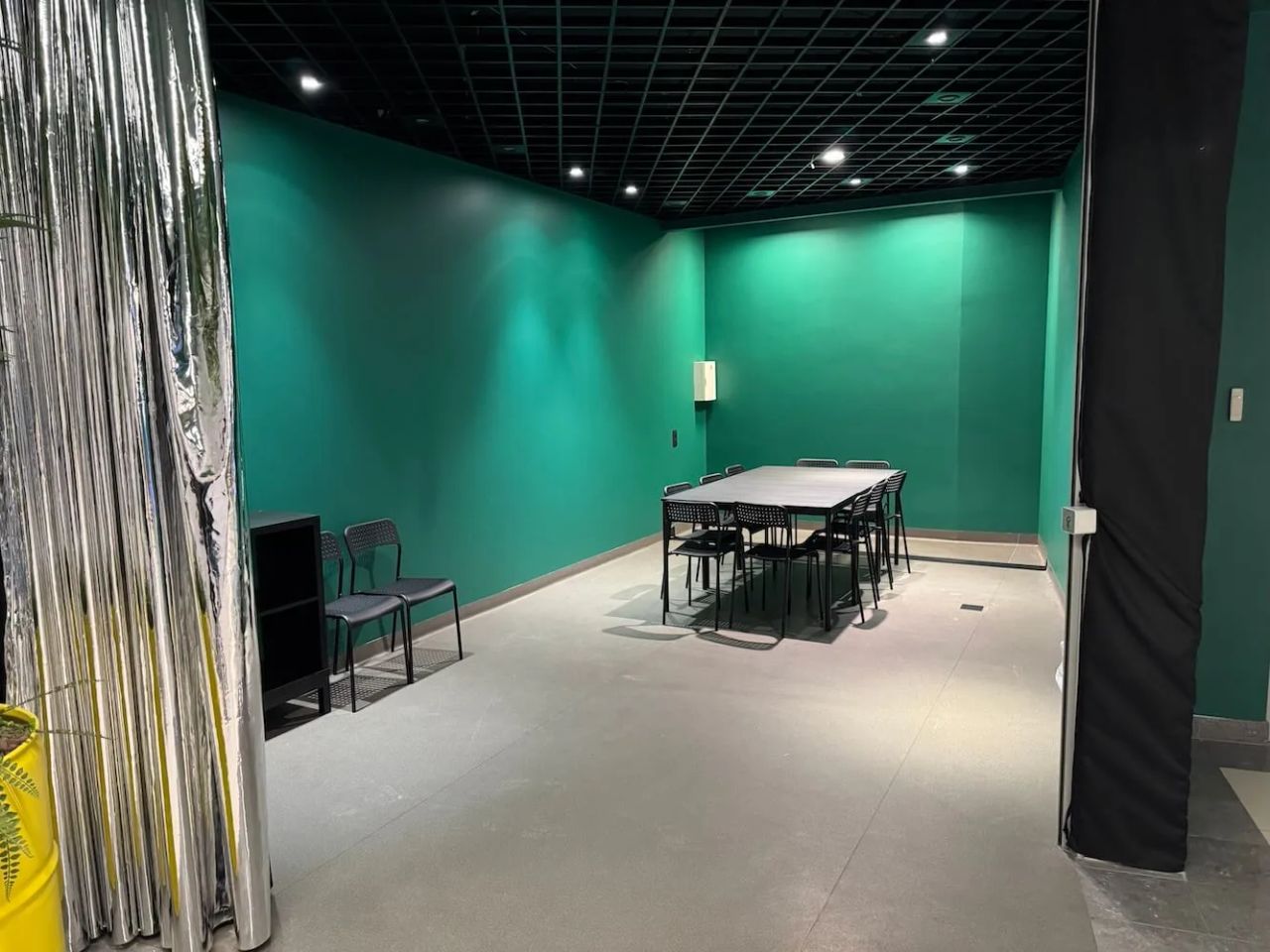 The party room at Galerija Centrs, table and chairs behind the curtain
