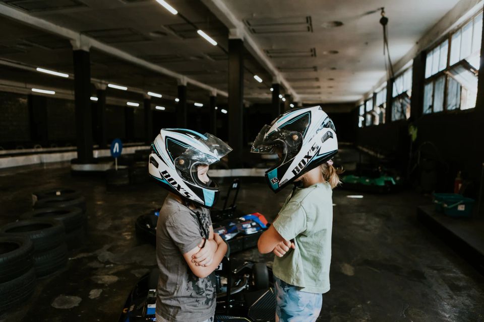 children driving go-karts on an indoor track