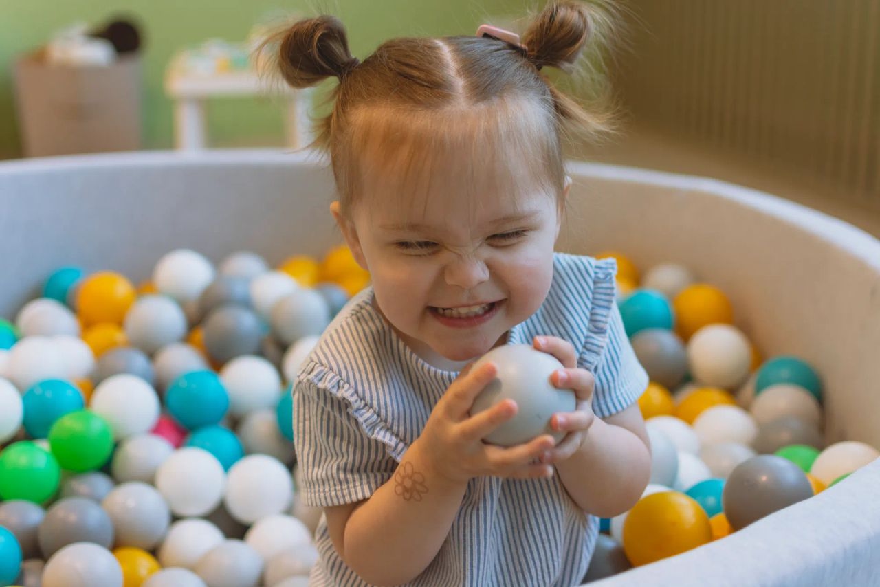 child playing in the ball pit in the kids playroom
