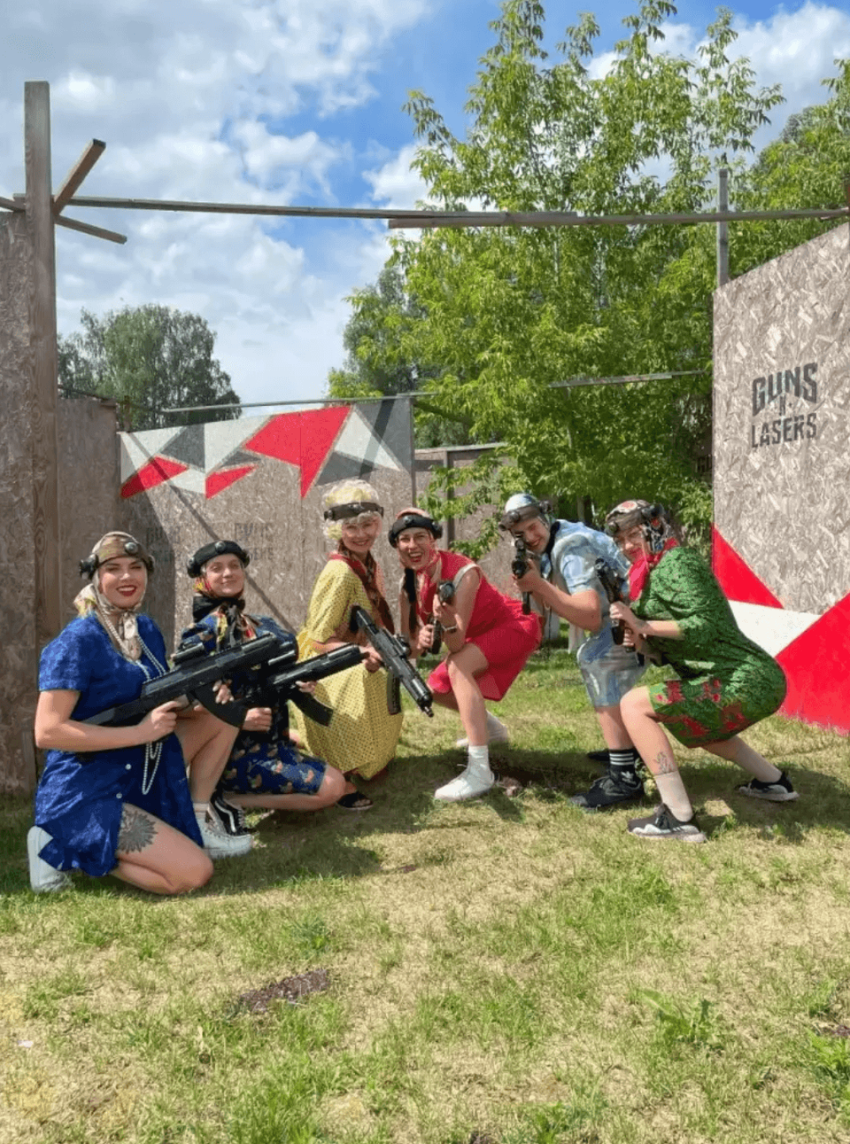 Girls playing laser tag on an outdoor playing field.