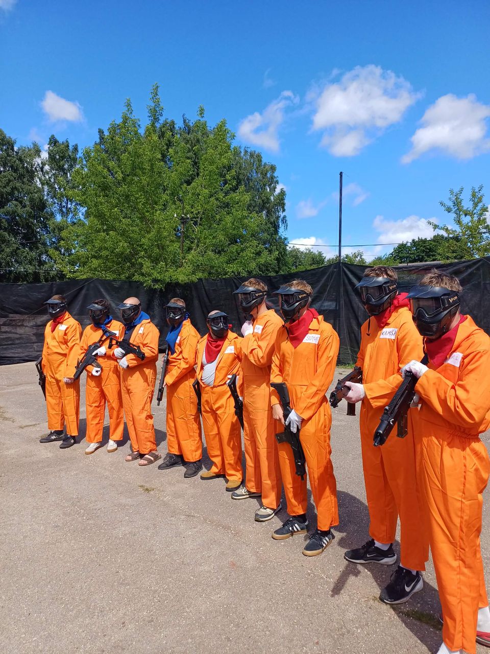 Rinda vecpuišu oranžās maskās, airsofta spēle